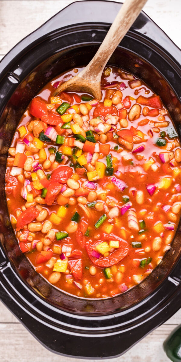 close up of vegetarian chili in slow cooker with spoon in it.