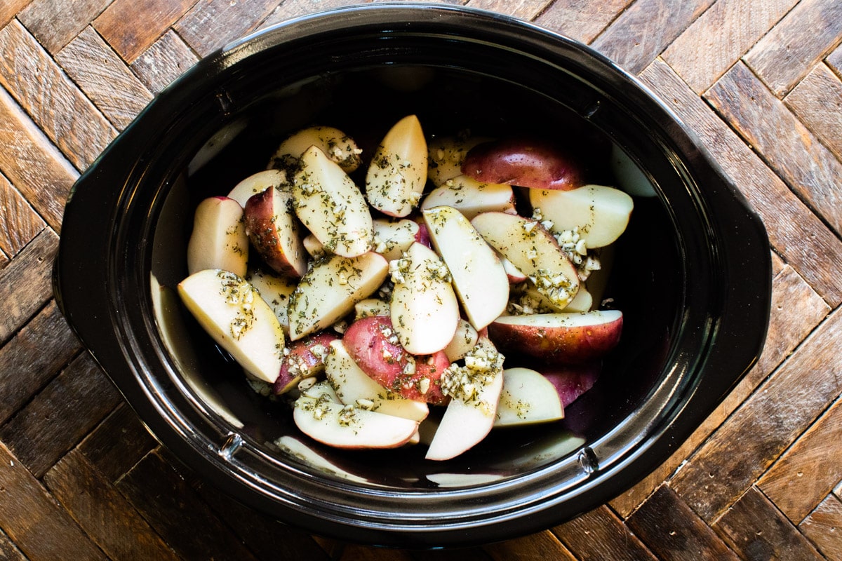 potatoes, garlic and oil in slow cooker