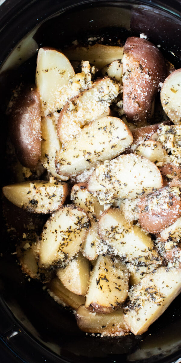 long close up image of garlic parmesan potatoes in slow cooker