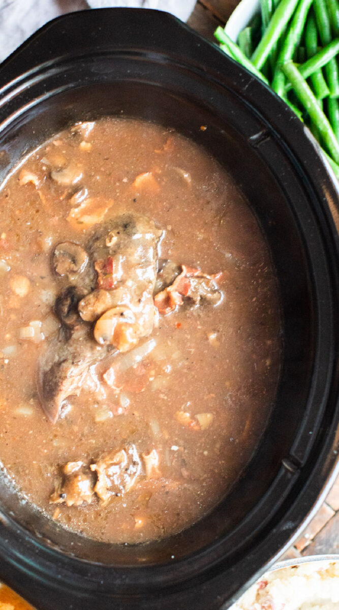 close up of venison roast in mushroom bacon gravy in slow cooker