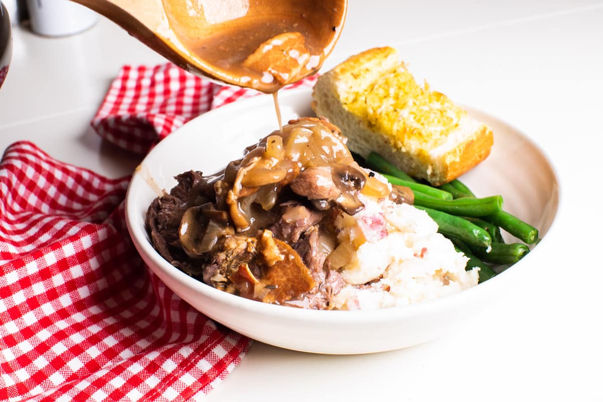 gravy being poured over venison roast