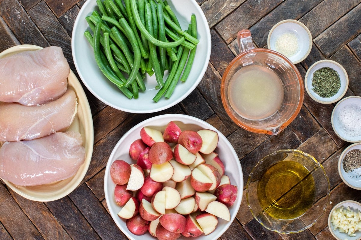 ingredients for chicken and vegetable slow cooker meal on wooden table