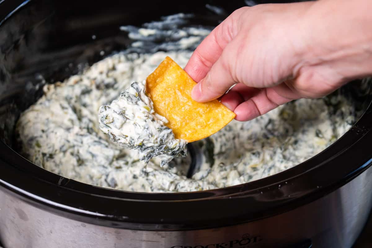 chip dipping out spinach dip in slow cooker