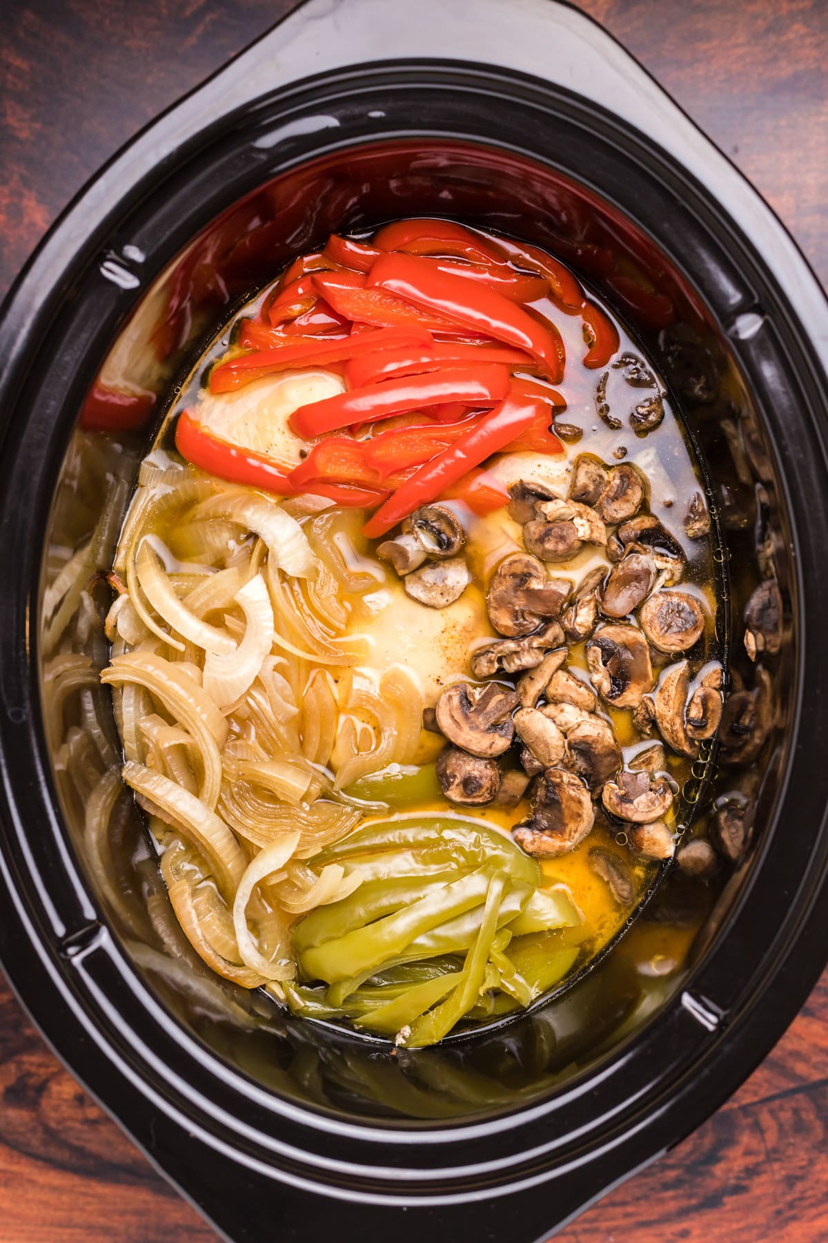 image of chicken, bell peppers, onions and mushrooms in slow cooker
