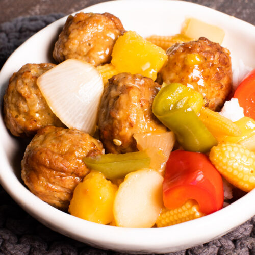 sweet and sour meatballs in bowl over rice