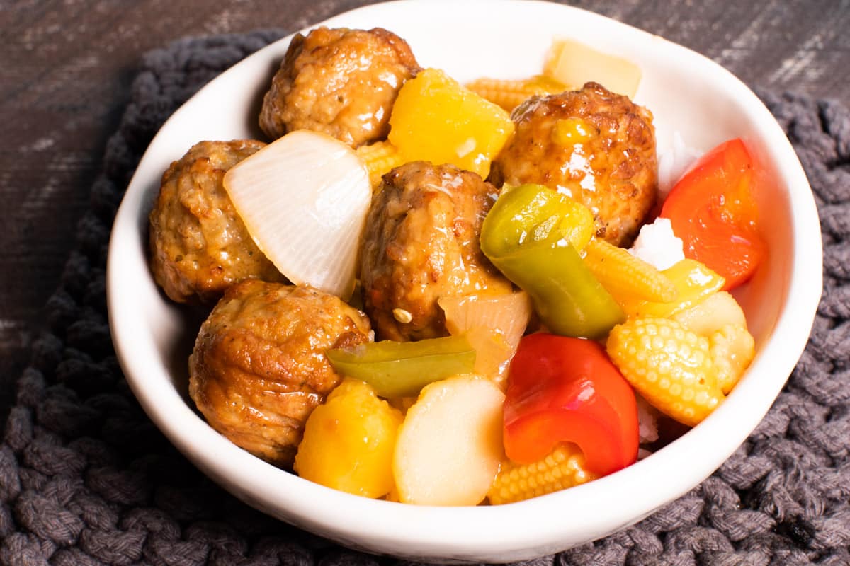 sweet and sour meatballs in bowl over rice