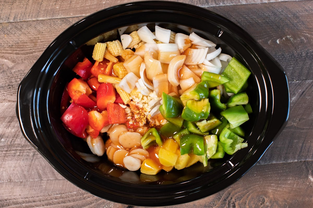 ingredients for sweet and sour meatballs not yet stirred in slow cooker