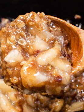 close up of apple crisp on wooden spoon