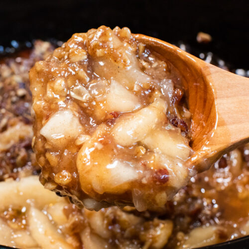 close up of apple crisp on wooden spoon