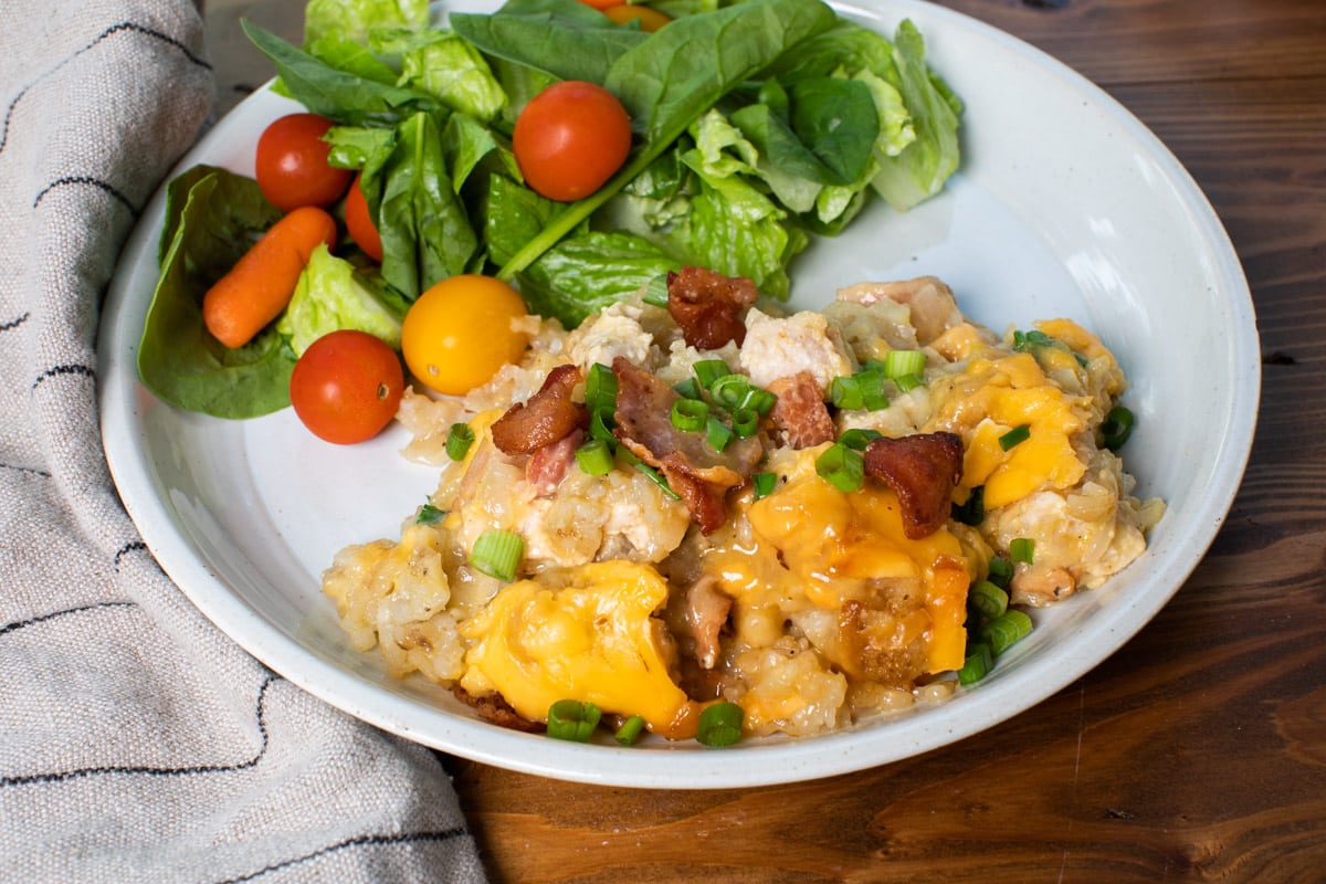 serving of chicken tater tot casserole on plate with salad