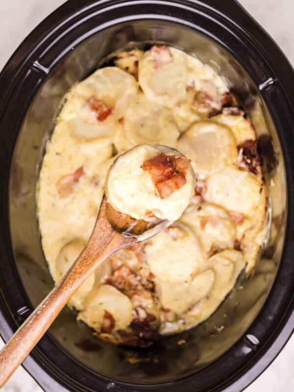 scalloped potatoes on a wooden spoon.