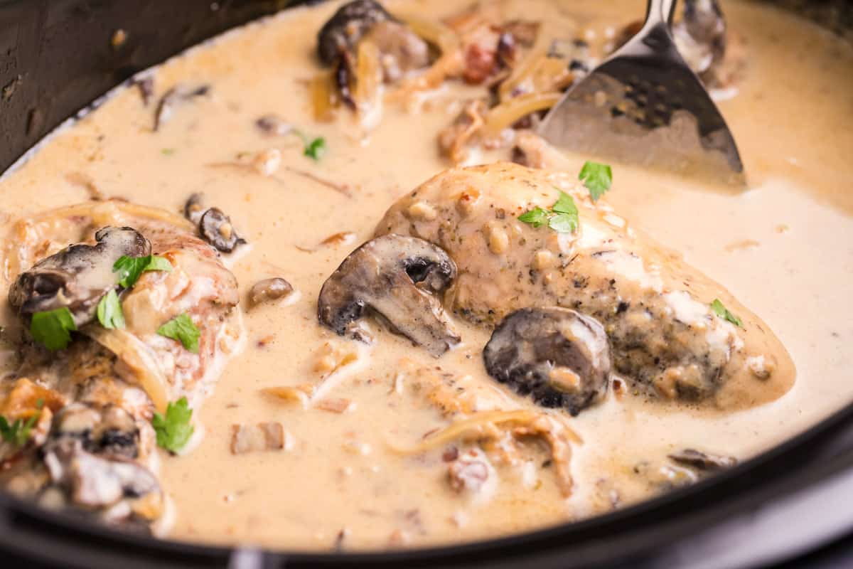 close up of chicken marsala in slow cooker with parsely on top.