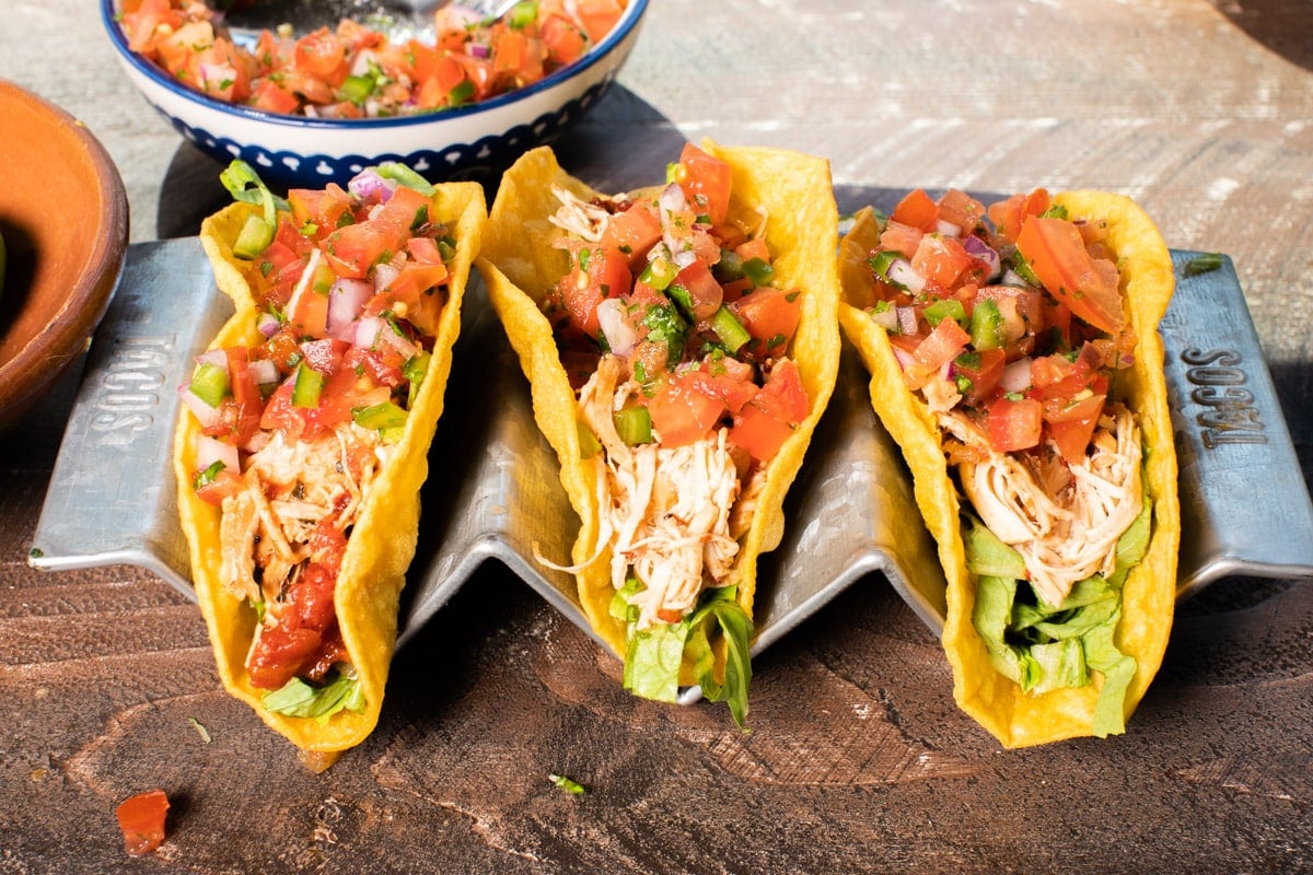 3 taco shells with chicken tinga and topping in them