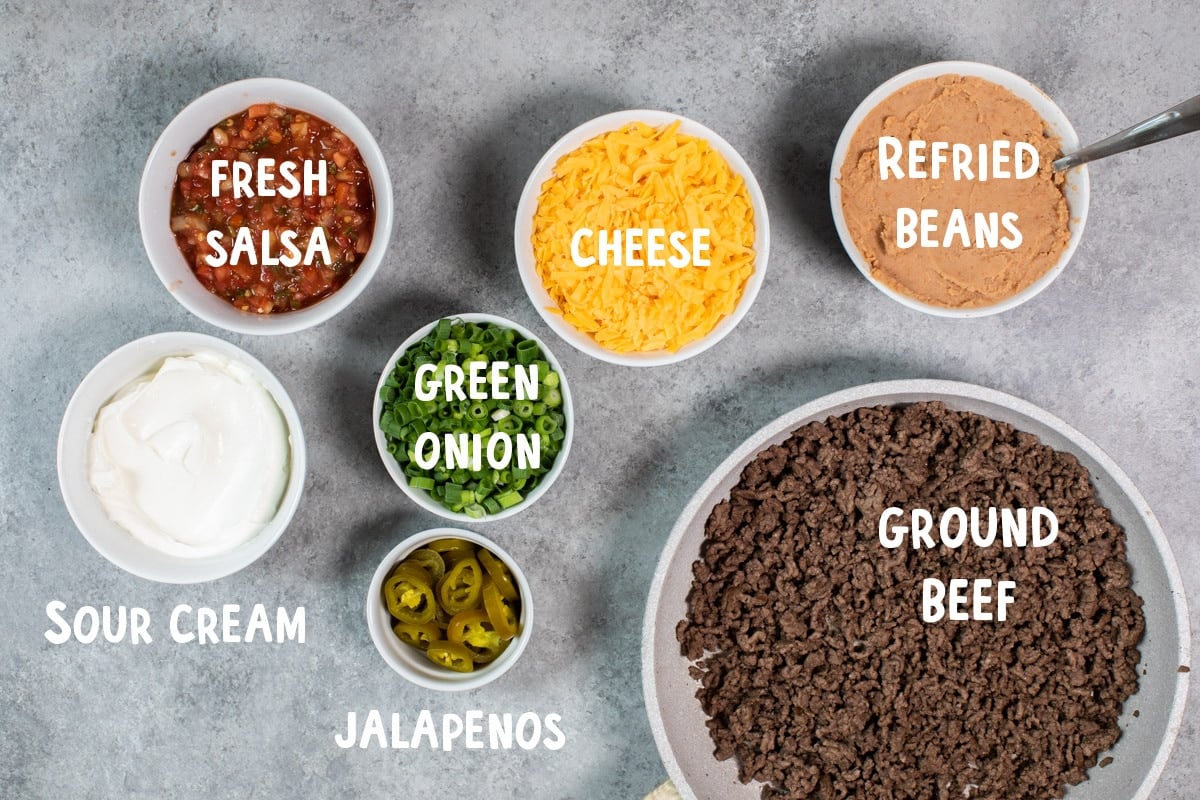 ingredients for 7 layer bean dip on table. With text overlay