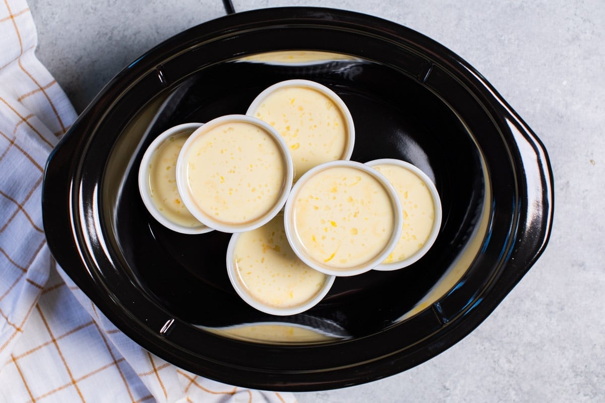 6 ramekins full of flan mixture in slow cooker (with water surrounding them)