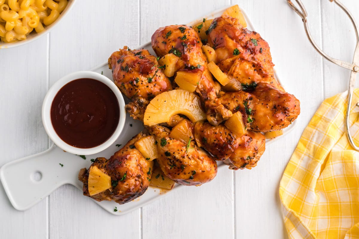 tray of cooked drumsticks with bbq sauce on the side