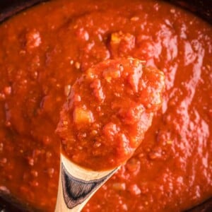 marinara sauce on a spoon coming from slow cooker