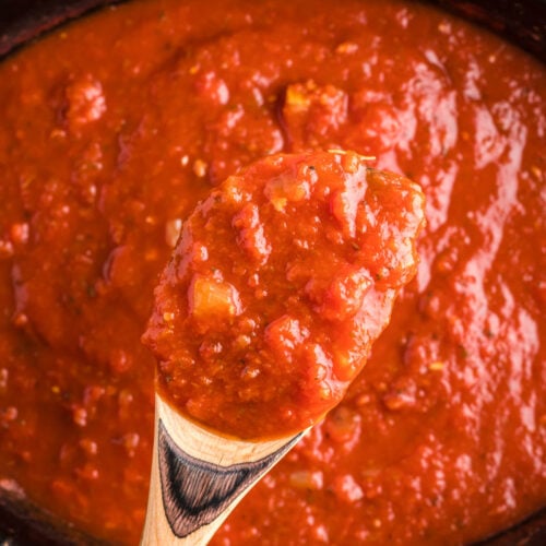 marinara sauce on a spoon coming from slow cooker