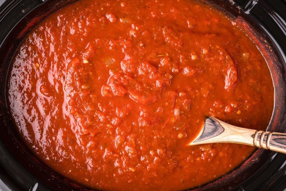 cooked marinara sauce in slow cooker with spoon