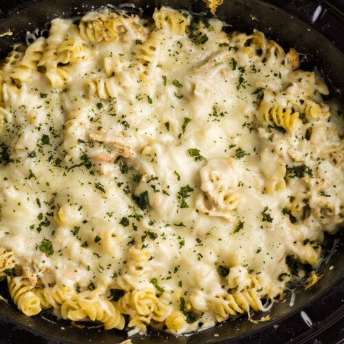 pesto pasta with cheese and parsley on top.