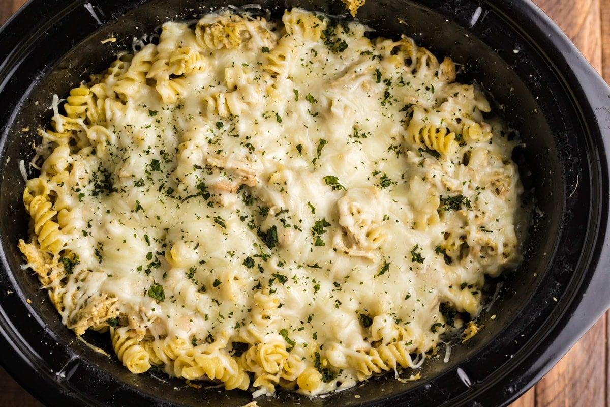 pesto pasta with cheese and parsley on top.