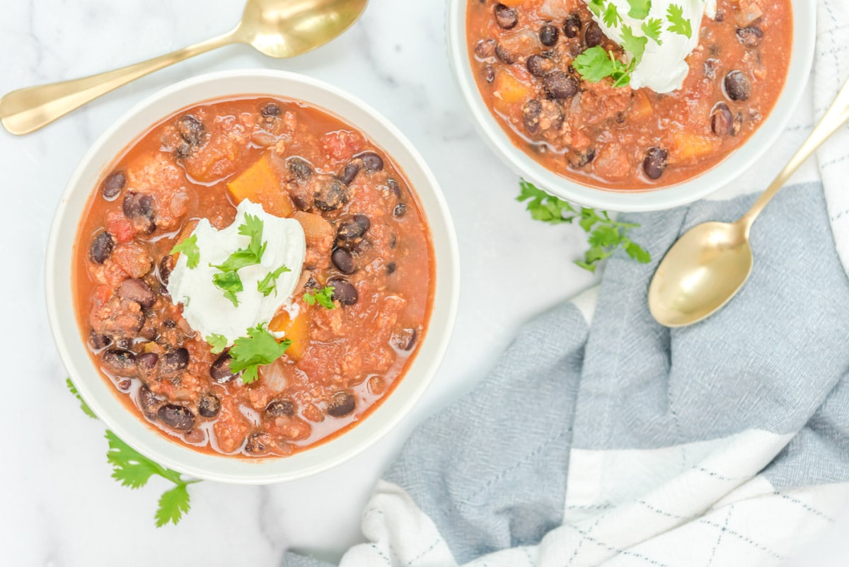 2 bowls of chili with sour cream on top