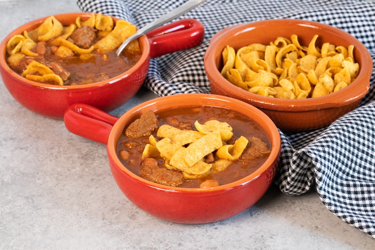 chili in red bowl with fritos on top.