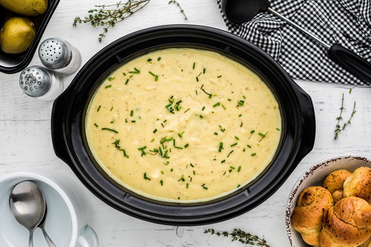 finished potato leek soup in slow cooker with leeks on top