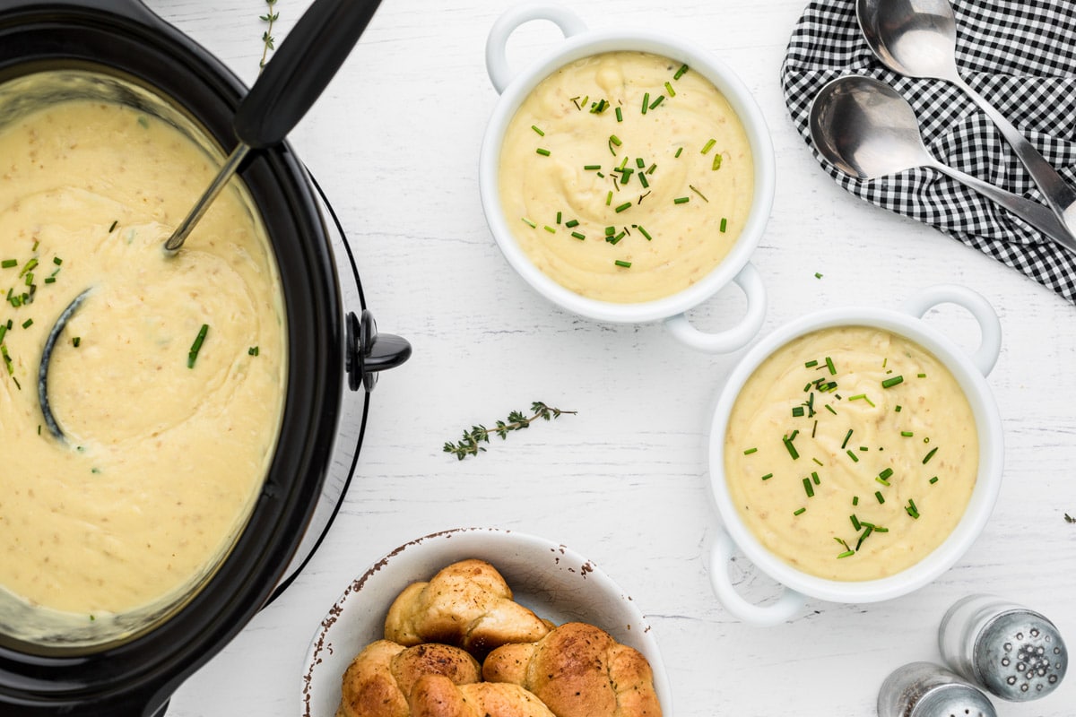 over head shot of slow cooker and bowls of potato leeks soup