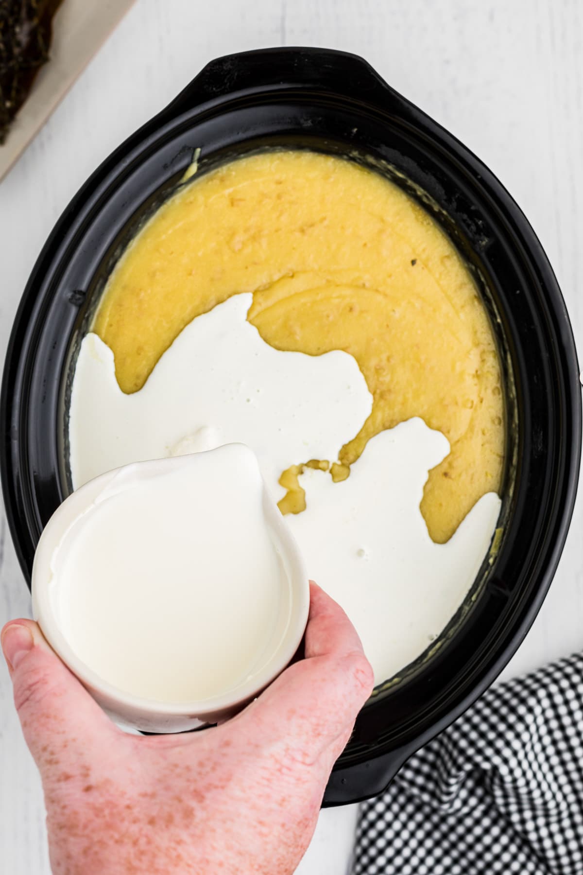 Heavy cream being added to potato leek soup.