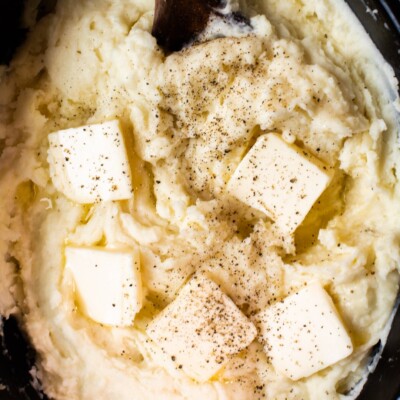 close up of mashed potatoes with butter on top.