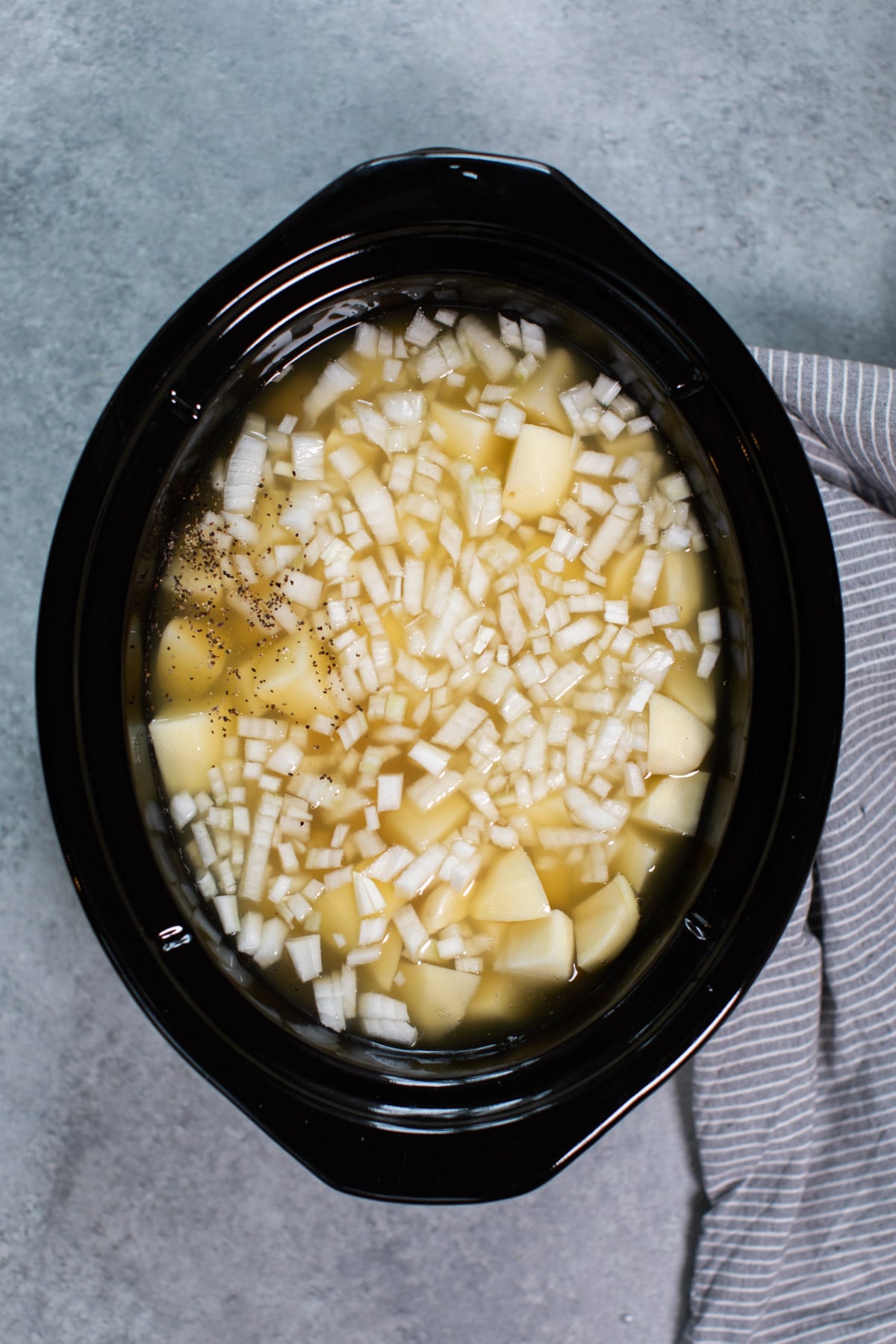 russet potatoes, onion, pepper and chicken broth in a slow cooker.