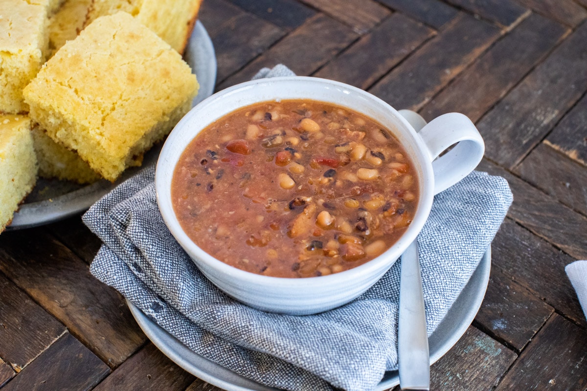 bowl of black eyed peas with corn bread on side