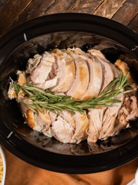 cooked turkey breast in slow cooker with sides around it
