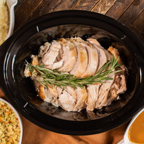 cooked turkey breast in slow cooker with sides around it