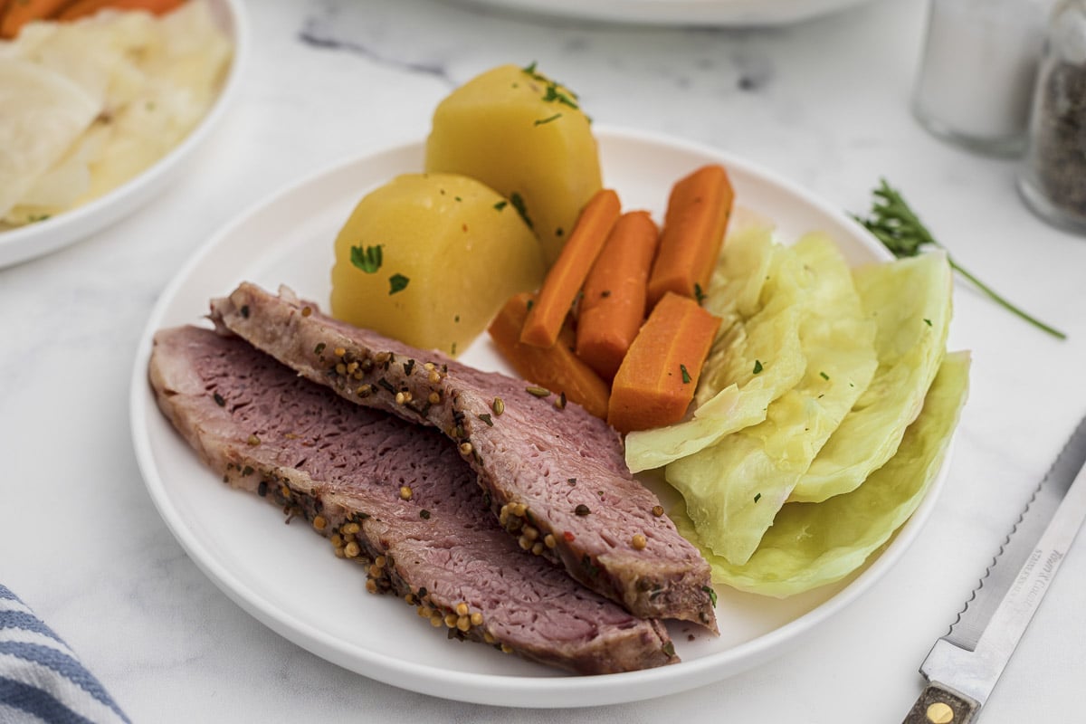 sliced corned beef on plate with carrots,and potatoes