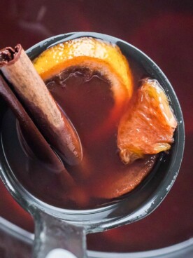cranberry crockpot citrus tea in a metal ladle