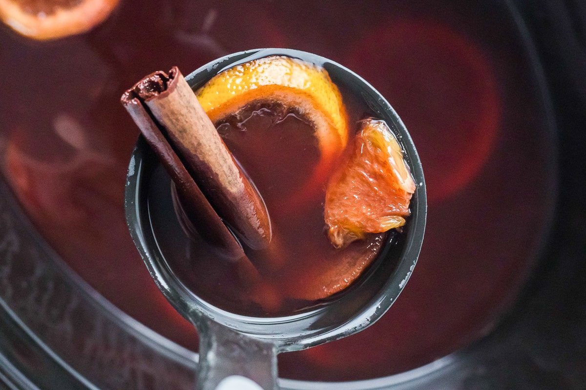 cranberry crockpot citrus tea in a metal ladle