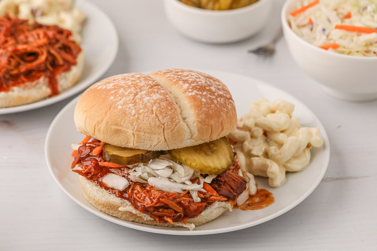 shredded barbecue chicken on a bun with coleslaw