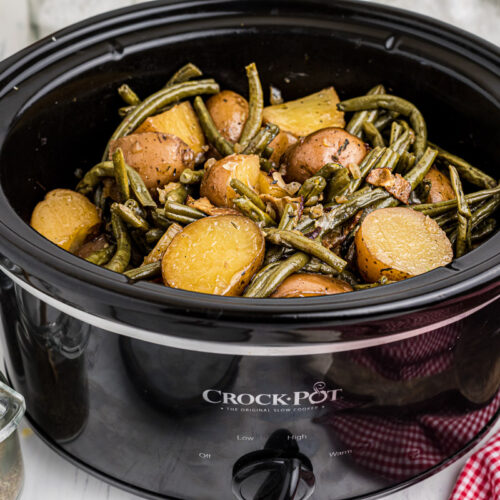 side view of slow cooker filled with green beans and potatoes