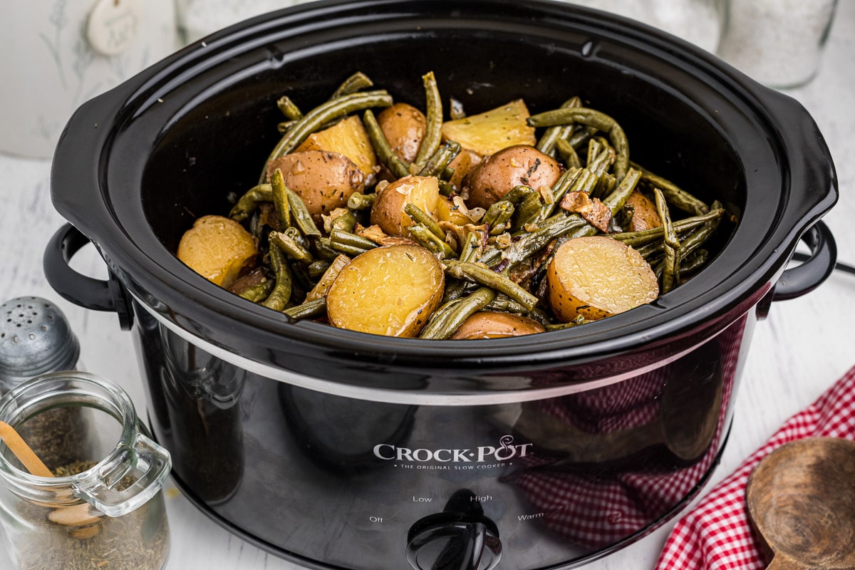 side view of slow cooker filled with green beans and potatoes