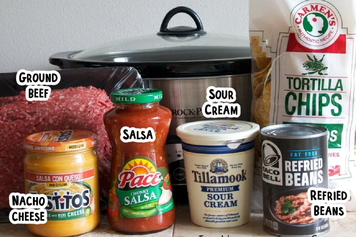ingredients for taco dip on table with text labels