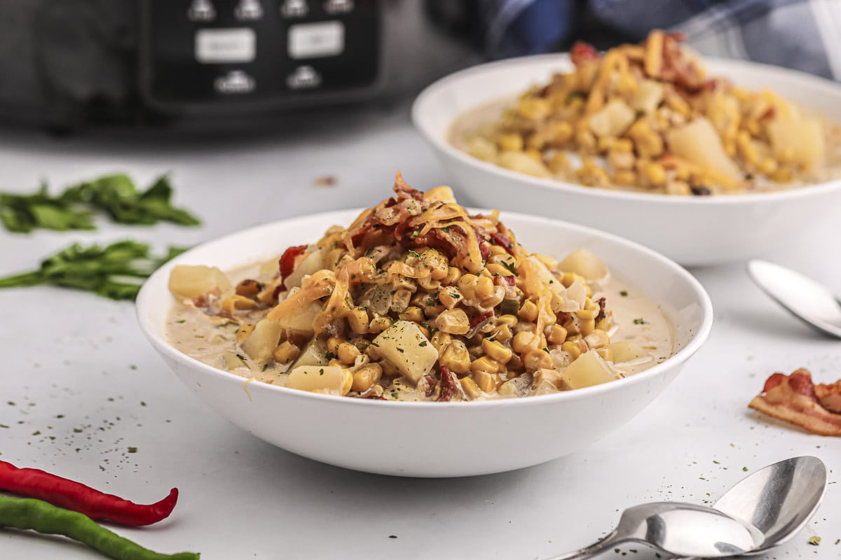 2 bowls of corn chowder in front of crockpot