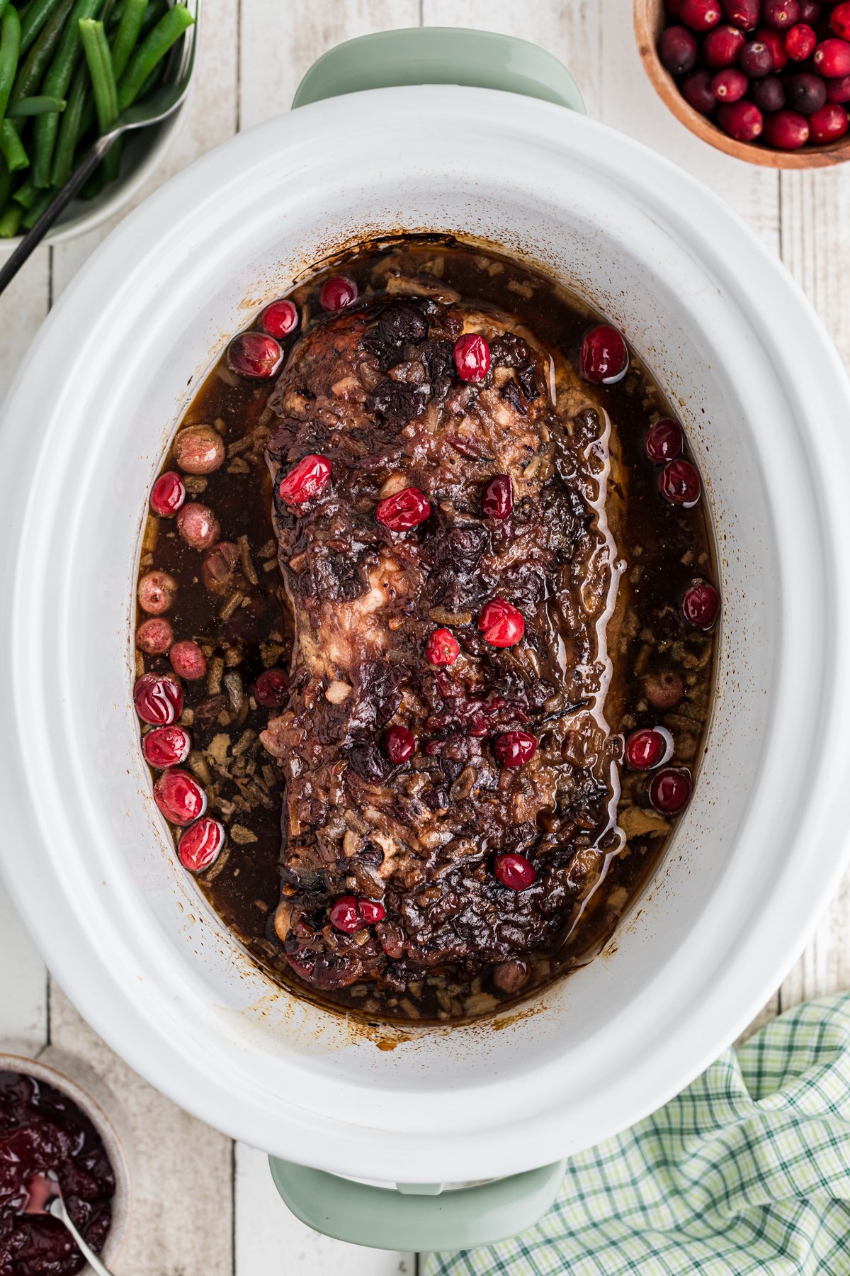 Pork loin in a slow cooker with cranberry sauce.
