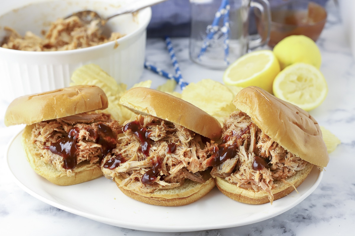 3 pulled pork sandwiches on buns and bbq sauce
