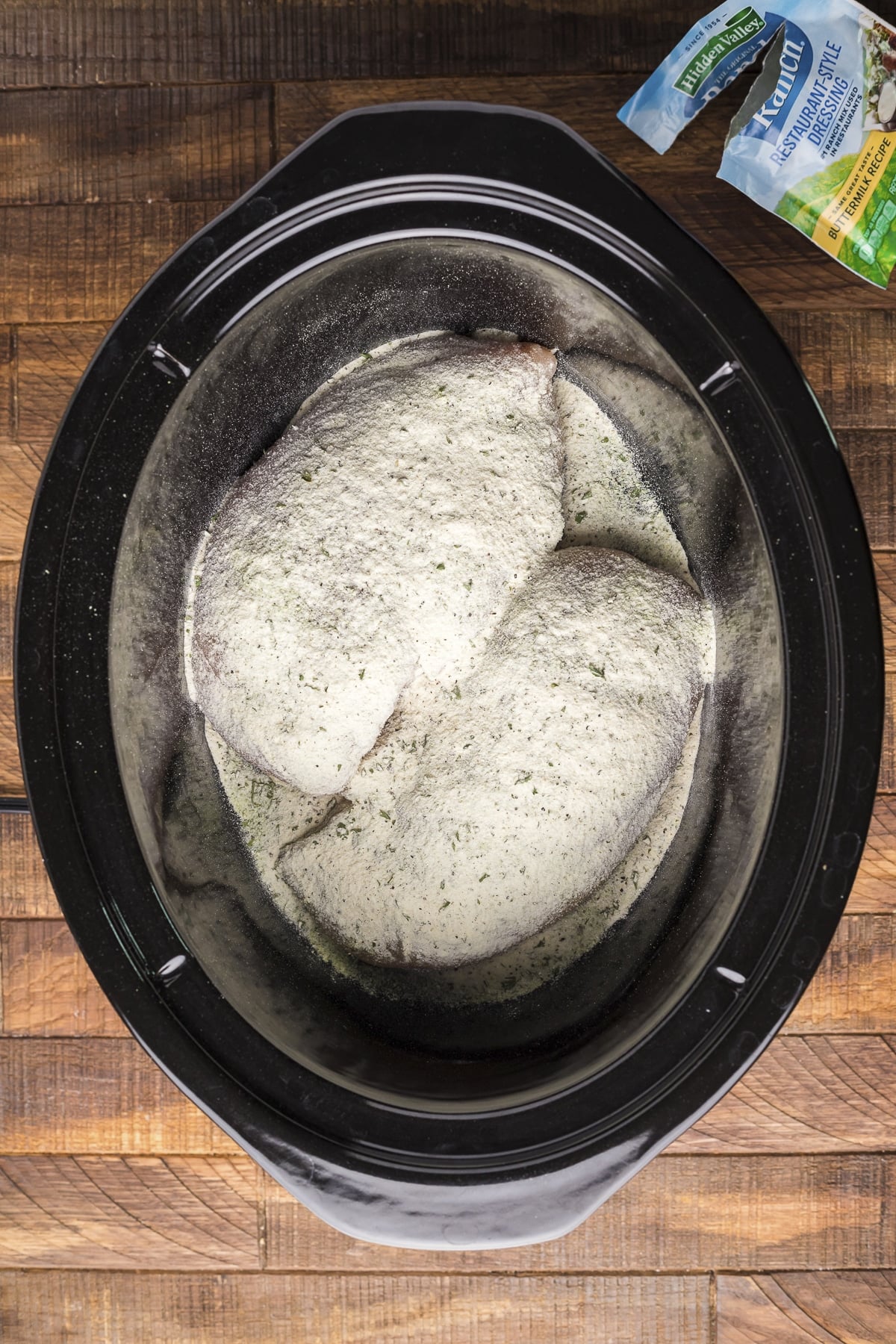 ranch powder and chicken breasts in a slow cooker.