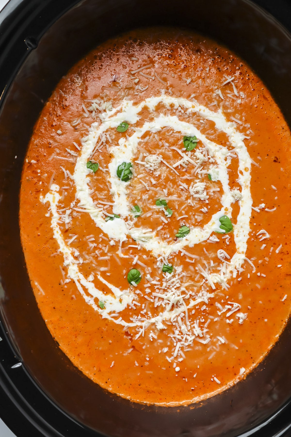 tomato soup in slow cooker with cream drizzle