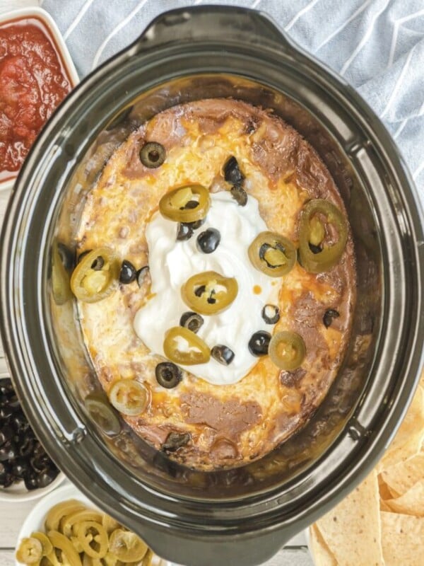 Cooked texas trash dip in the slow cooker with olives and jalapenos.