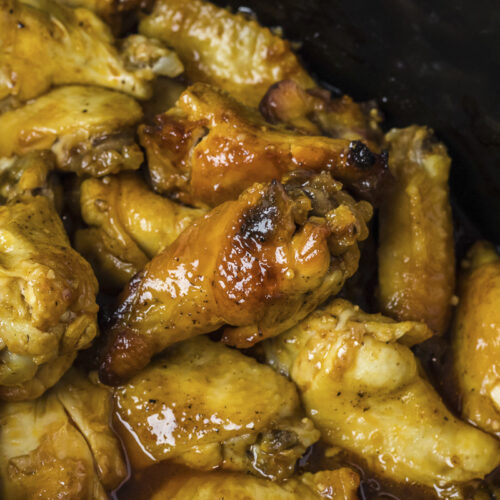 close up of cooked honey mustard wings in slow cooker