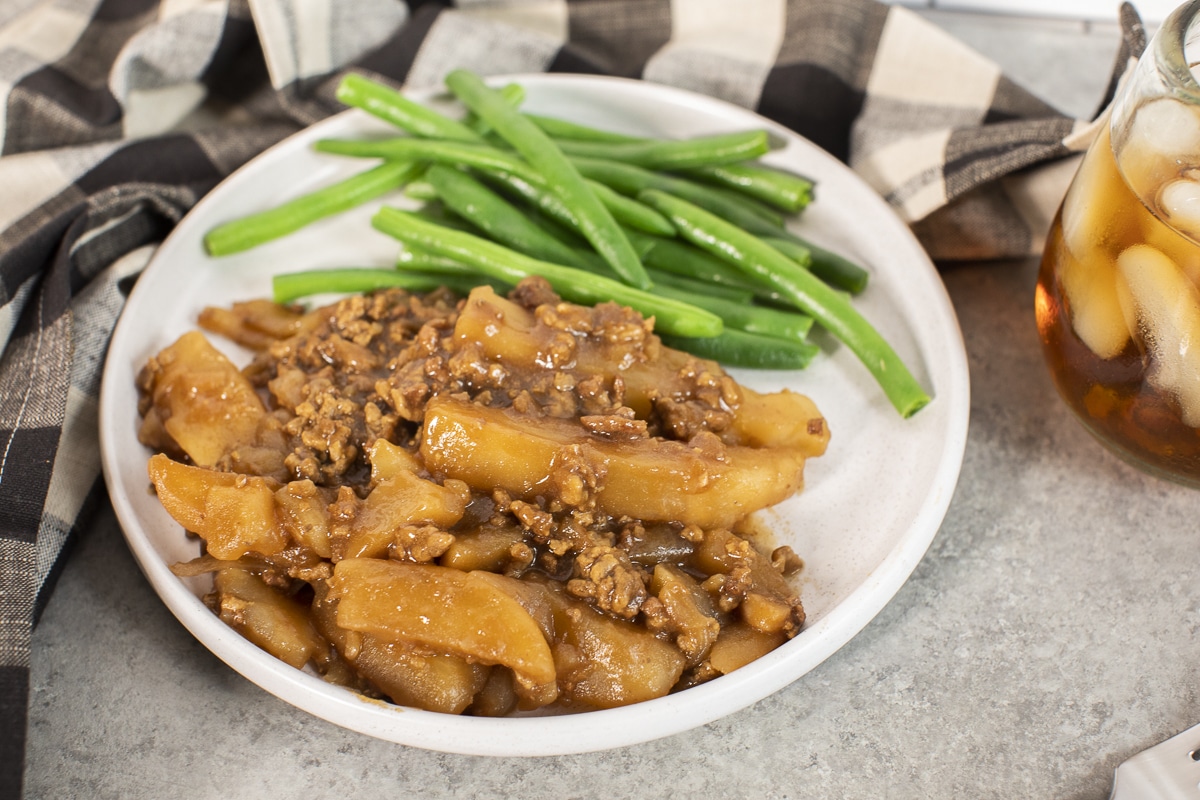 plate of beef and potato casserole with green beans.